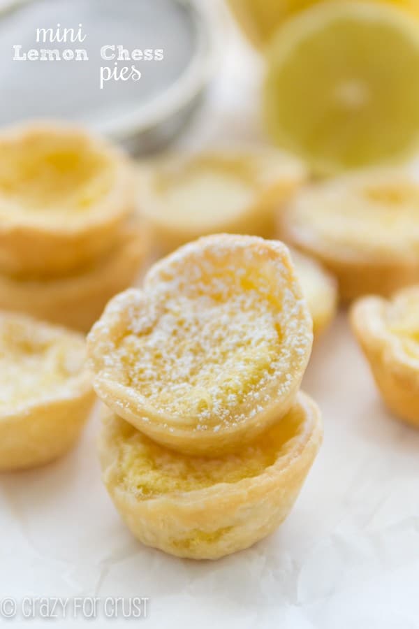 Mini Lemon Chess Pies stacked on top of each other with lemons in the background 