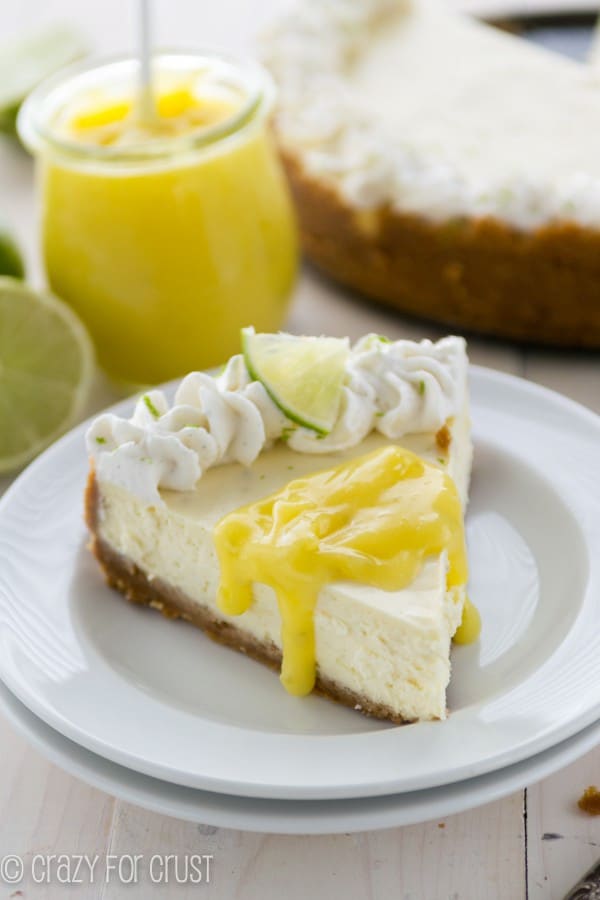 Key Lime Cheesecake on a white plate with a drink in the background