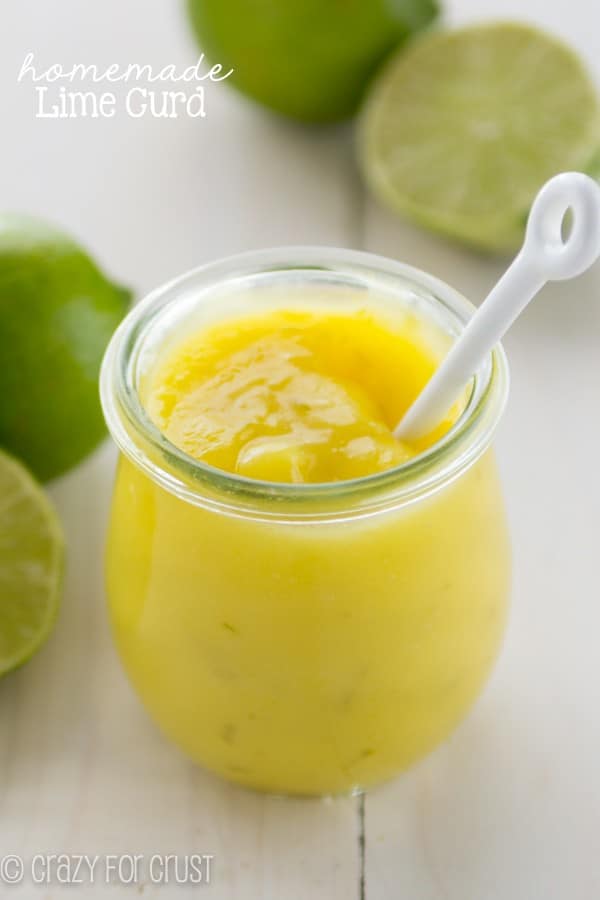 Homemade Lime Curd in In a small clear glass with limes all around the glass
