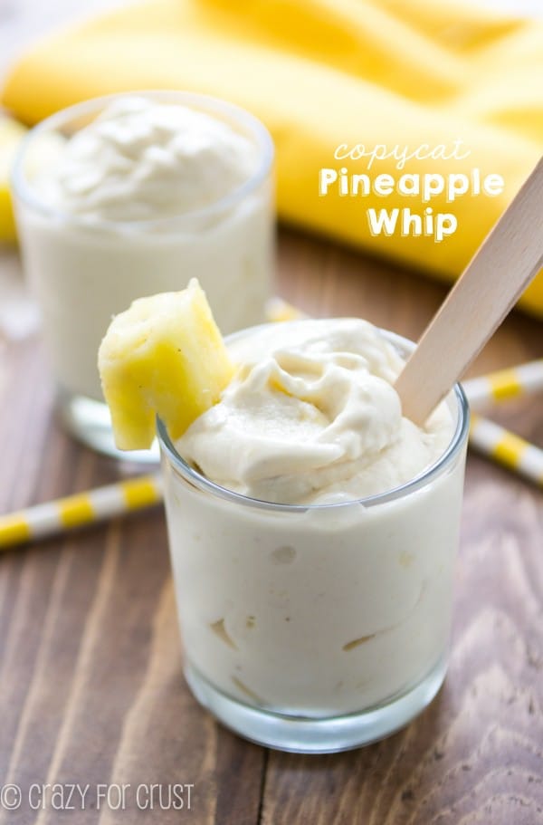 Copycat Pineapple Whip in a short clear glass with a piece of pineapple on the glass