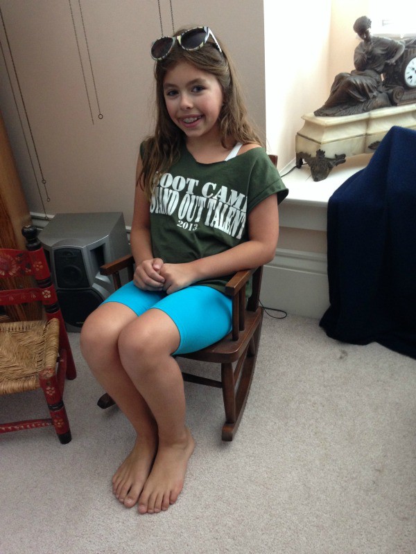 rocking chair 2014 (9 years old), Girl wearing a green shirt and blue biker shorts 