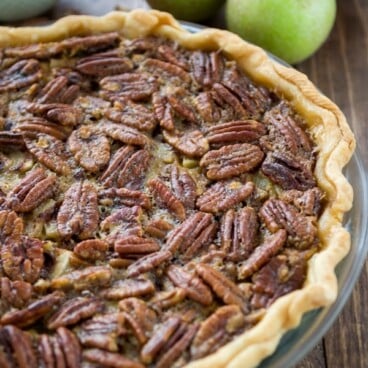 apple pecan pie with apples behind