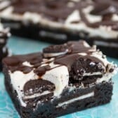 brownie on teal napkin with frosting and oreos