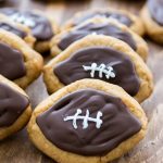 stack of football shaped peanut butter cookies with decorations on top