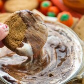 hand holding cookie dipping it in smore dip