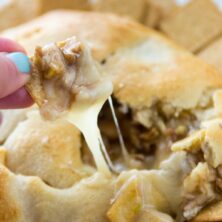 Apple Pecan Pie Baked Brie has apples and pecans are cooked until soft and baked with sugar and brie in a crescent roll crust.