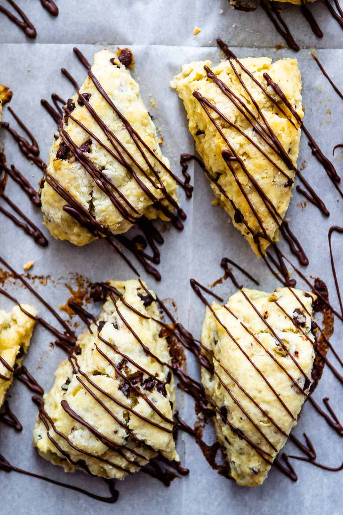 scones on a white plate with chocolate drizzled on top.