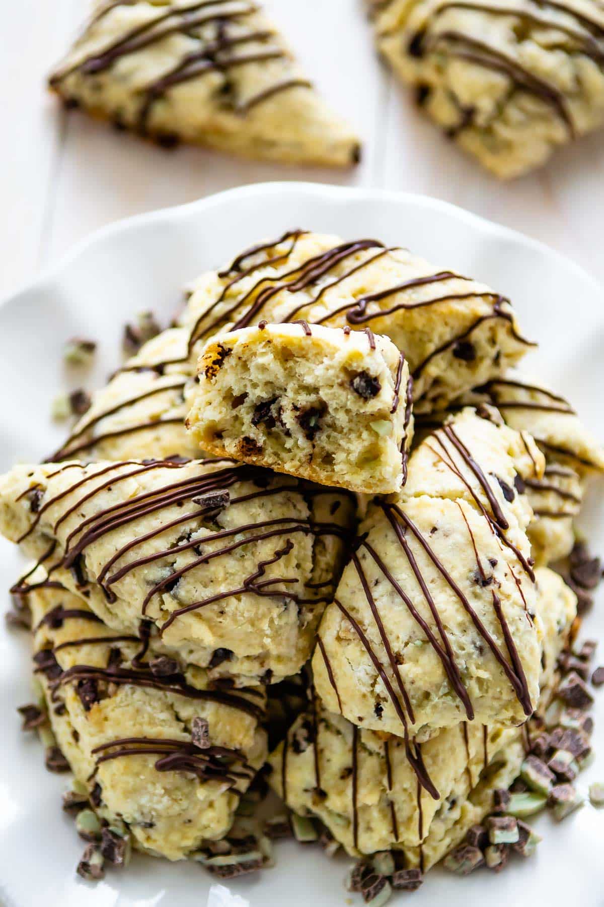 scones on a white plate with chocolate drizzled on top.