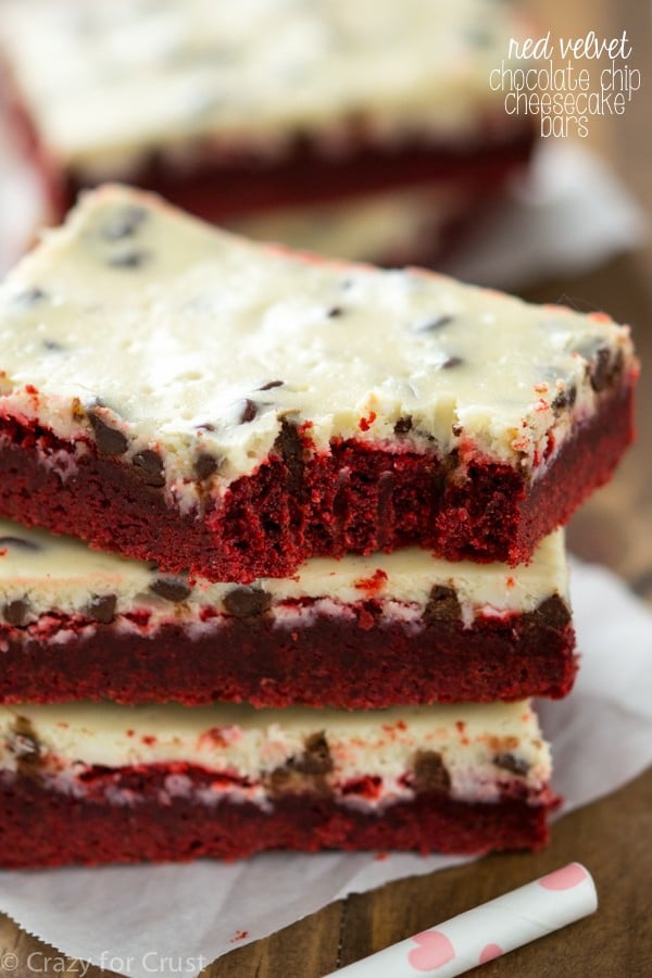 Red velvet cheesecake bars stack on parchment paper