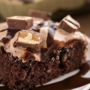 Snickers Poke Cake on a white plate