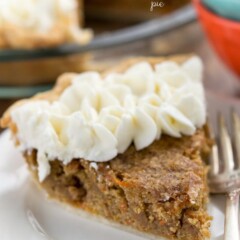 slice of carrot cake pie with whipped cream on white plate and fork