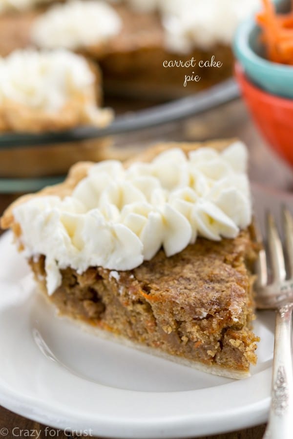 slice of carrot cake pie with whipped cream on white plate and fork