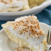 Slice of Coconut Banana Cream Pie on a white plate with a fork