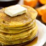 stack of orange pancakes on white plate