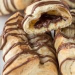 Chocolate cheese danishes stacked ontop of eachother showing chocolate on the inside