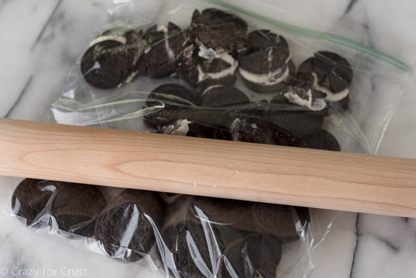 crushing Oreo cookies with a rolling pin to make an Oreo cookie crust