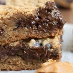 stack of 2 cookie bars with spoon of peanut butter