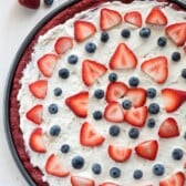 Overhead shot of red velvet fruit pizza with strawberries and blueberries