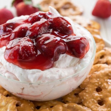 Strawberry Pretzel Salad Dip in a small glass bowl sitting on pretzels