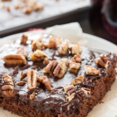 Slice of coca cola sheet cake on white plate with words at top of photo