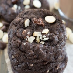 Stack of double chocolate macadamia nut cookies on parchment paper