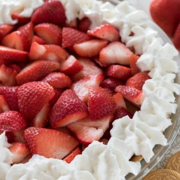 Close up shot of no bake strawberry shortcake pie with vanilla oreos and strawberries on the table