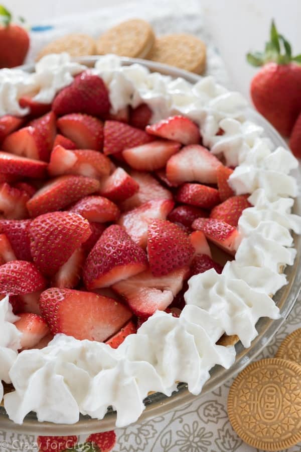 Close up shot of no bake strawberry shortcake pie with vanilla oreos and strawberries on the table