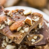 Peanut butter almond roca pieces on white plate