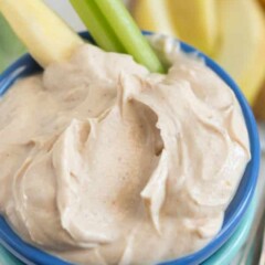Skinny peanut butter dip in small blue bowl with celery