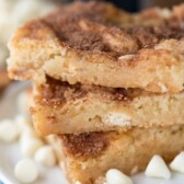 Stack of white chocolate snickerdoodle gooey bars on white plate