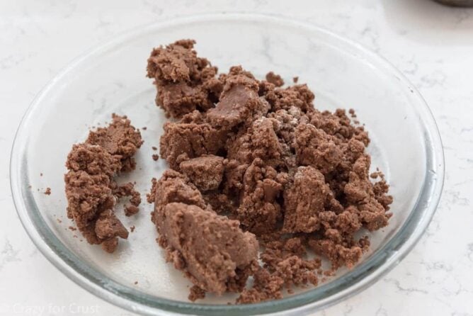 No Roll Chocolate Pie Crust being put into a glass pie plate