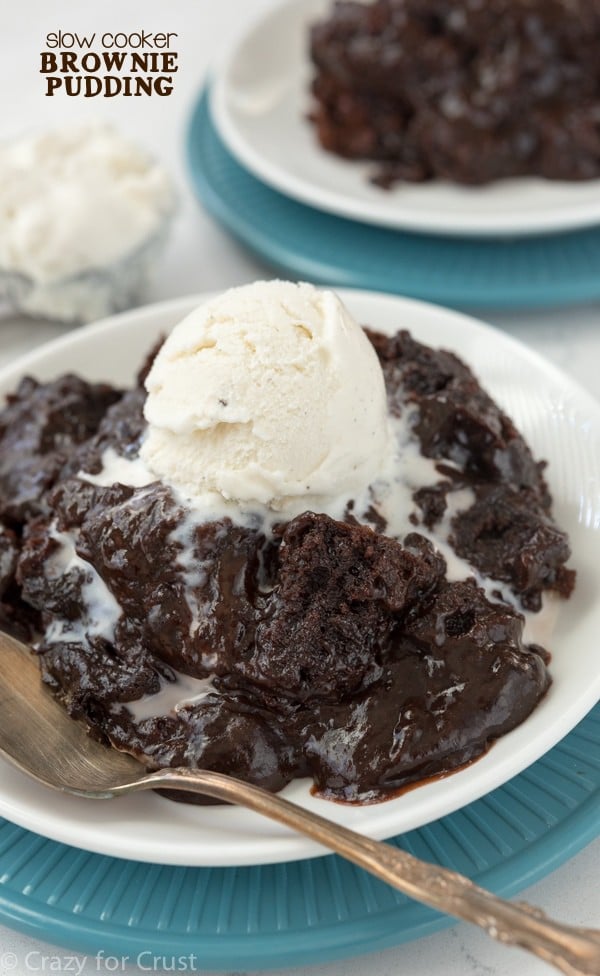 Slow cooker brownie pudding on white plate with turquoise plate under