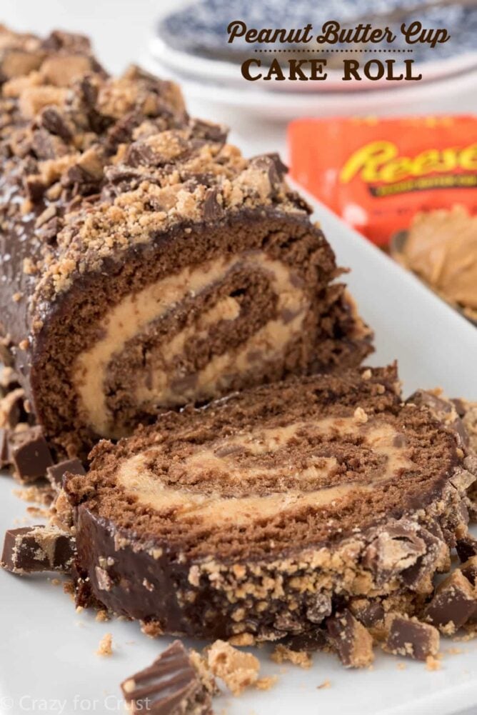 chocolate cake roll with peanut butter filling and peanut butter cups on white platter