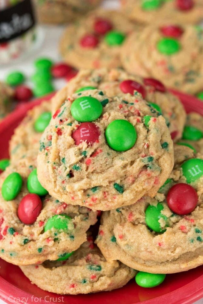 close up of pudding cookies with red and green m and ms on red plate