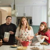 Christmas card picture with a family of 3 in the kitchen