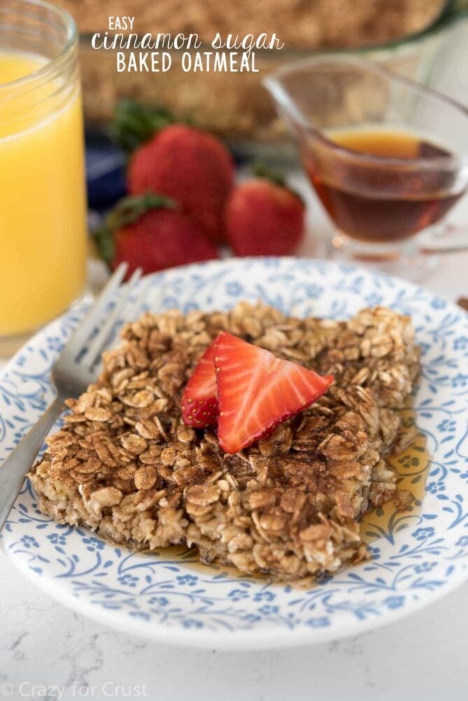 This Cinnamon Sugar Baked Oatmeal on blue plate with fork, strawberries, syrup and title