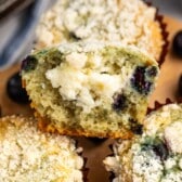 muffins with cream cheese and blueberries inside stacked together.