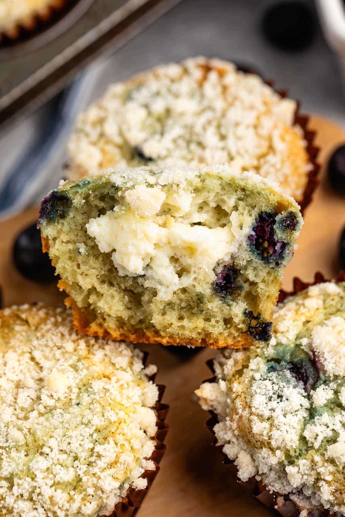 muffins with cream cheese and blueberries inside stacked together.