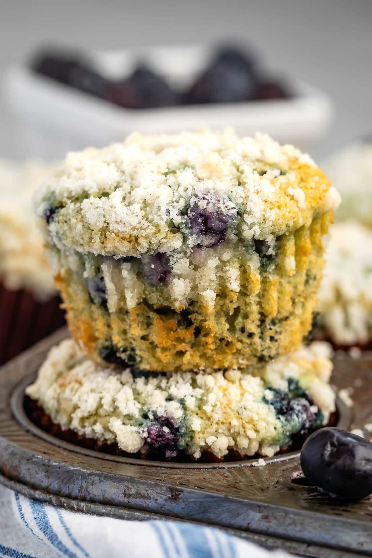 muffins with cream cheese and blueberries inside stacked together.