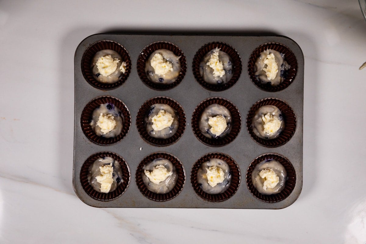 process shot of blueberry cream cheese muffins being made.