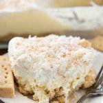 Slice of coconut cheesecake no bake dessert on white plate with fork