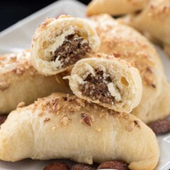 Almond baklava croissants on white plate with one split open to show filling