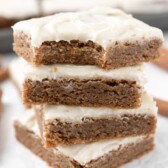 Stack of four cinnamon roll blondies with top one missing a bite