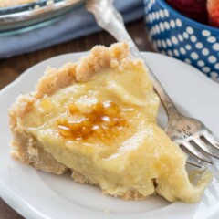 Slice of no bake creme brulee pie on white plate with silver fork