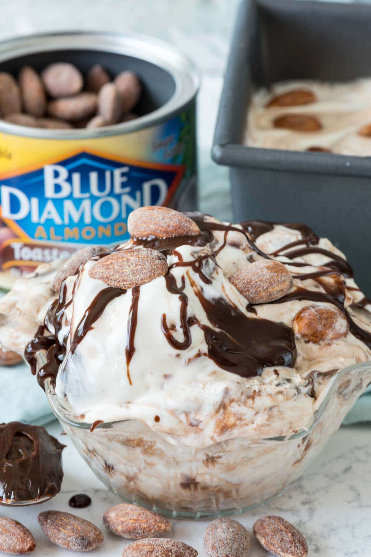 No churn almond fudge ice cream in a clear dish with almonds in the background