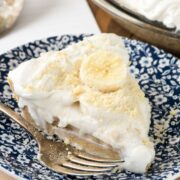 Slice of old fashioned banana pudding on white and blue flowered plate