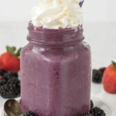 Skinny berry pie milkshake with whipped cream and fruit around the bottom