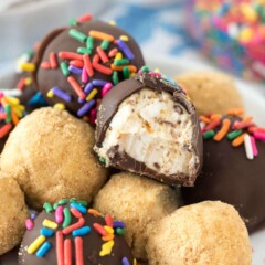 No bake cheesecake truffles dipped in chocolate and covered in sprinkles