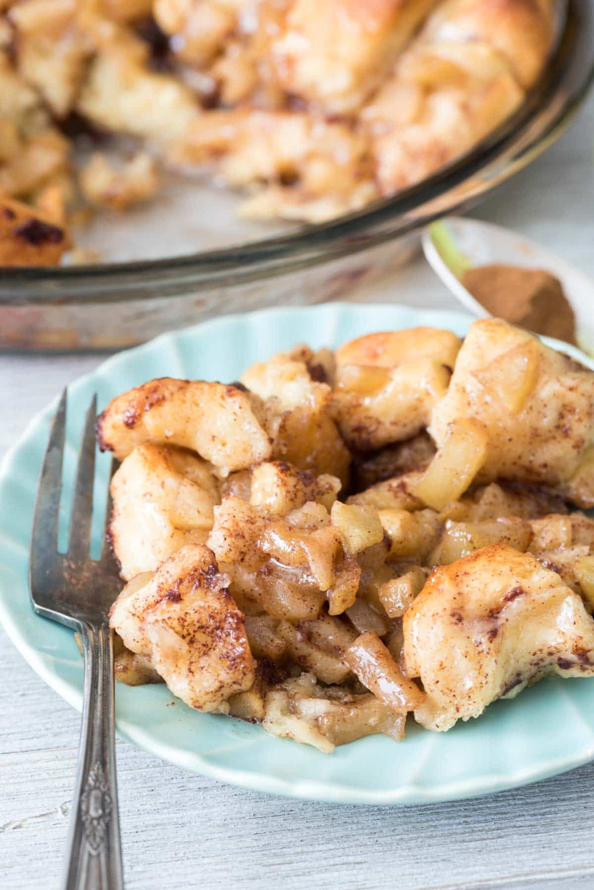 Easy Apple Fritter Cinnamon Roll Bake - canned cinnamon rolls mixed with cinnamon apples baked like monkey bread! It's like an apple fritter cinnamon roll!