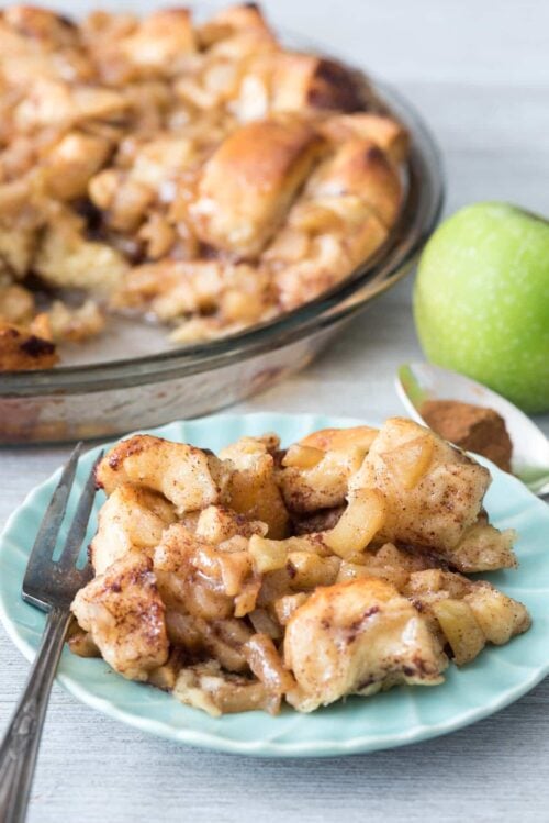 Apple Fritter Cinnamon Roll Bake on a green plate with a fork